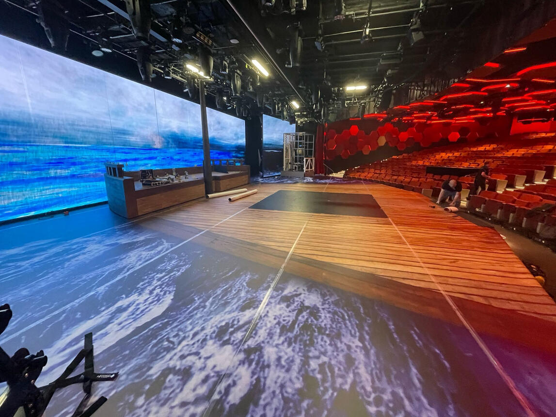 A stage covered in printed flooring like a ship.